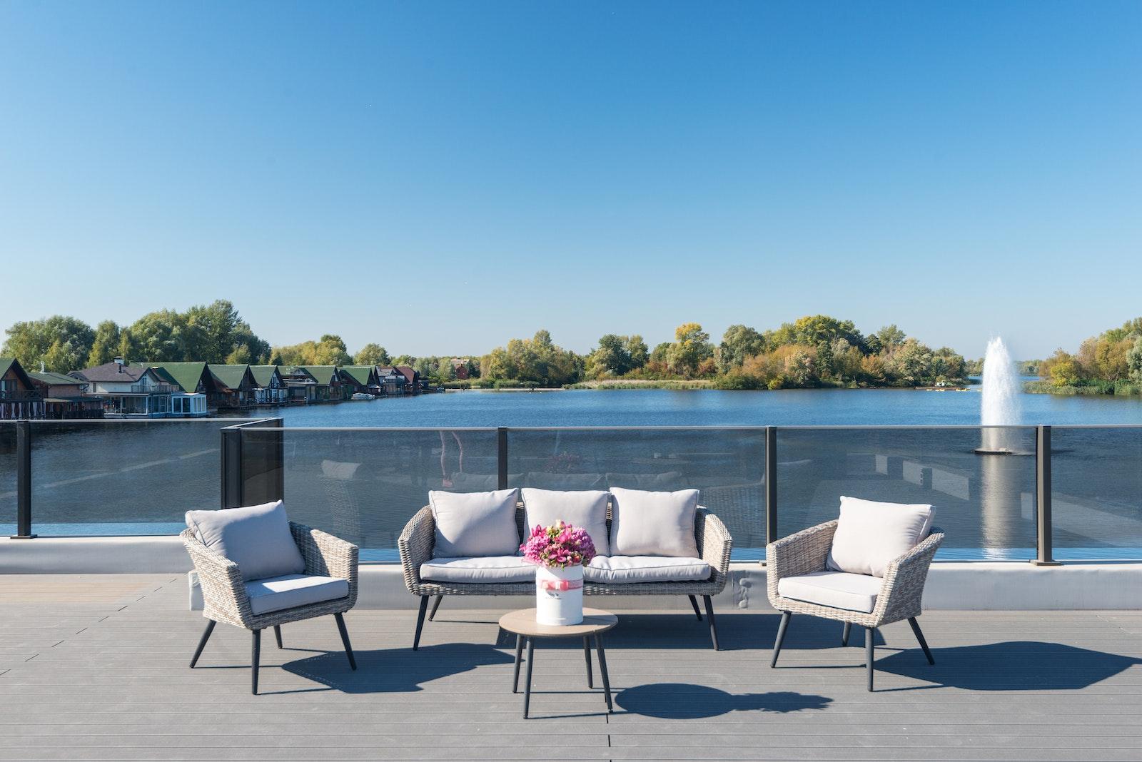 A Couch and Chairs on the Terrace Near the Glass Railing